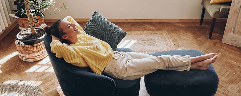 happy woman relaxing in her home, enjoying great indoor air quality and comfort
