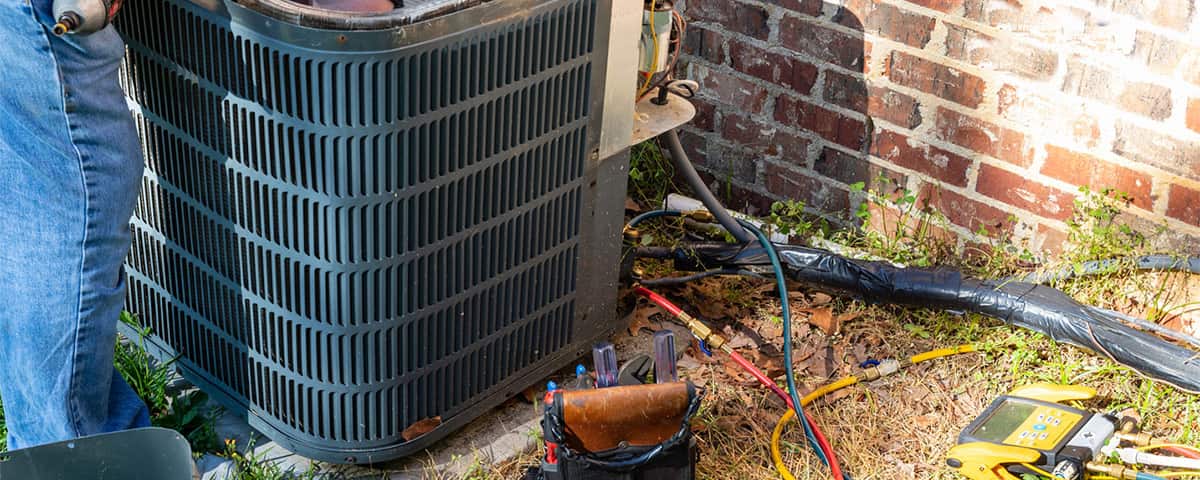 HVAC repairman fixing air conditioner